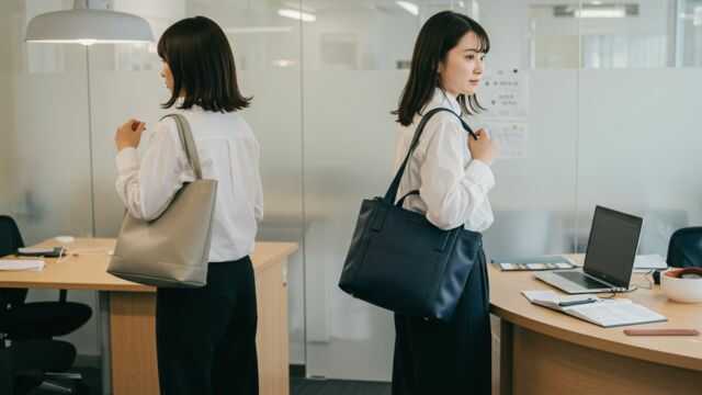 オフィスカジュアルな服装で働く20代の日本人女性たち。多様な通勤バッグが現代の職場スタイルと調和している様子